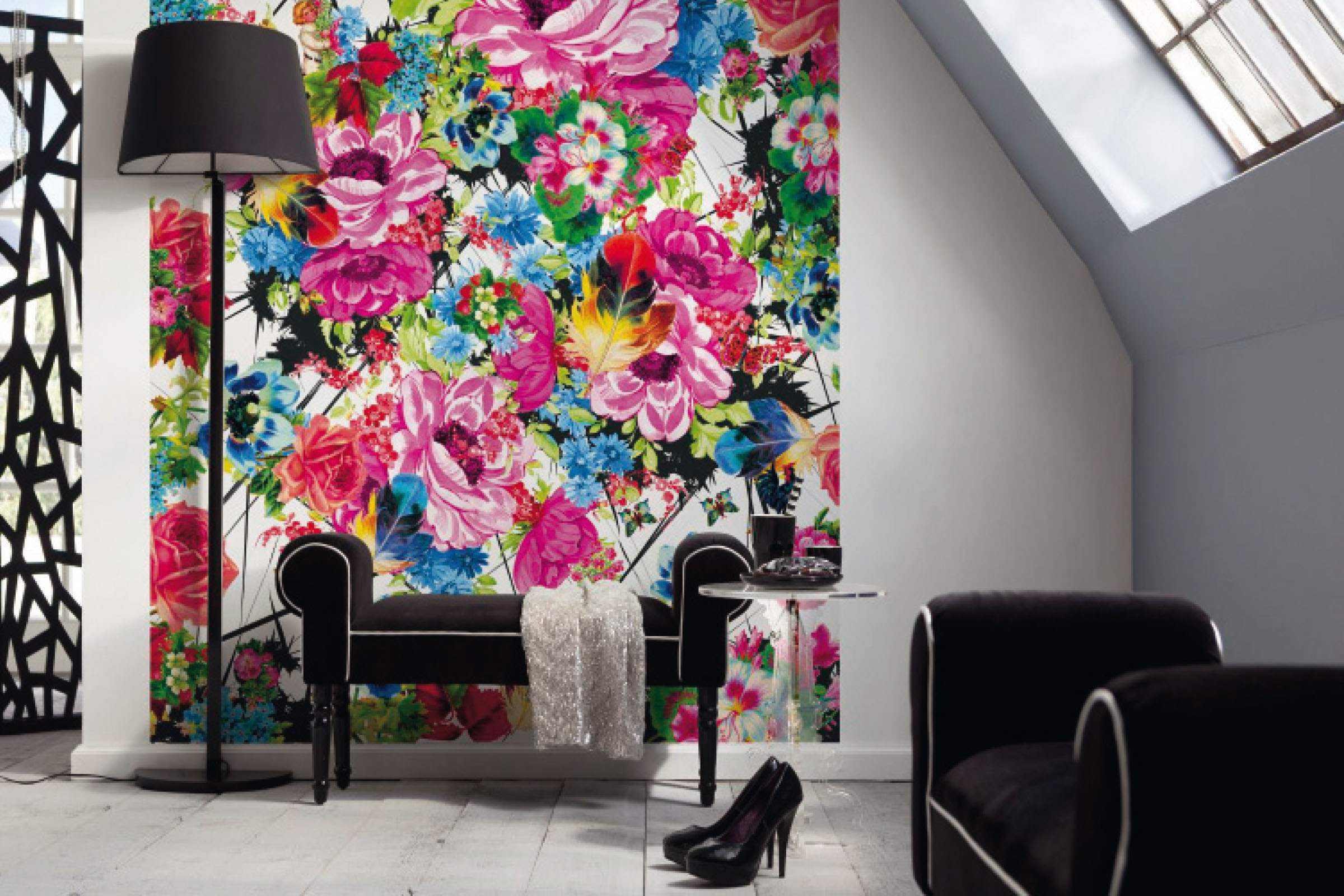 Cameră de zi cu tapet cu motive florale, lampadar și mobilier pentru ședere.