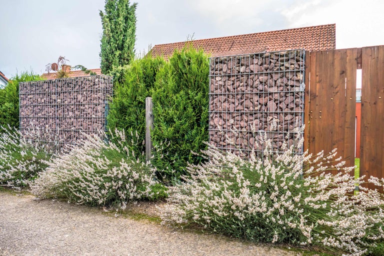 Gard gabion cu pietre și elemente din lemn în grădină