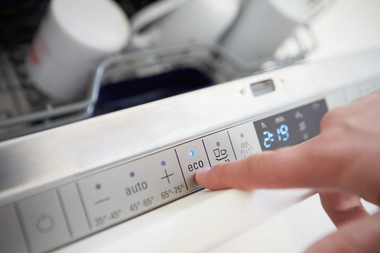 Panoul de control al unei mașini de spălat vase cu accent pe butonul Eco și afișajul digital al orei