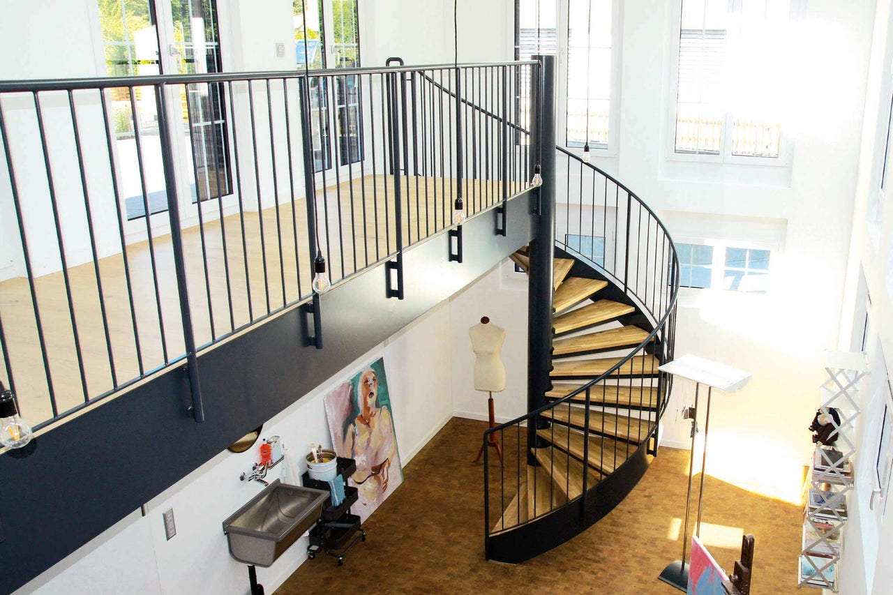 Fotografie de interior cu scară spiralată, balustradă și mansardă