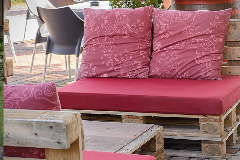 Mobilier din paleți cu perne și șezuturi roșii pentru exterior