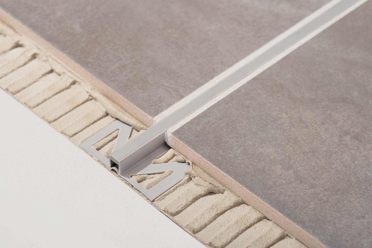 Vizualizare detaliată a unei șine metalice pentru faianță între două plăci