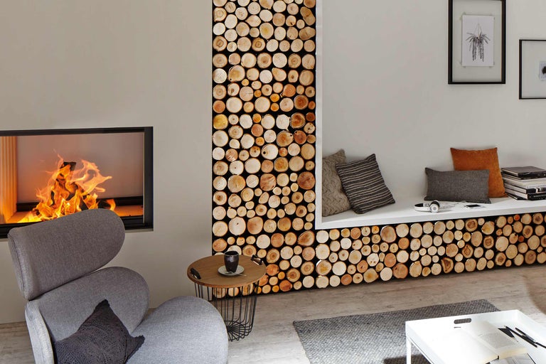 Living cu șemineu, fotoliu, măsuță laterală și panouri de perete cu aspect de lemn.