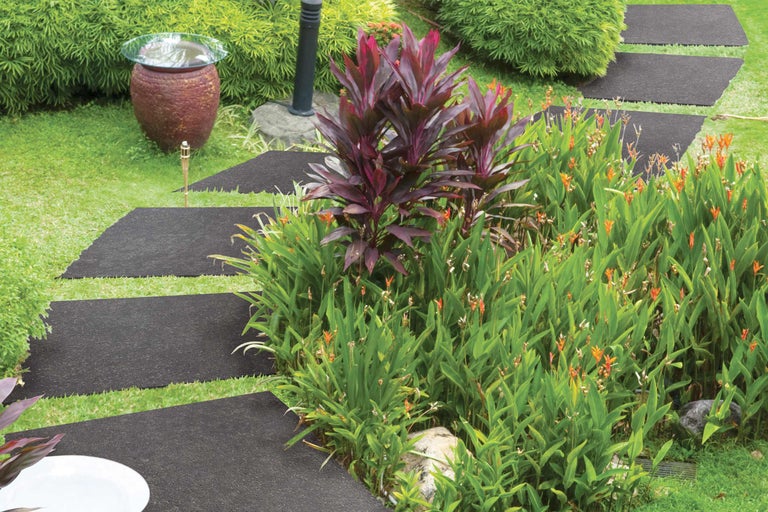 Alei de grădină din dale de pavaj printre plante verzi