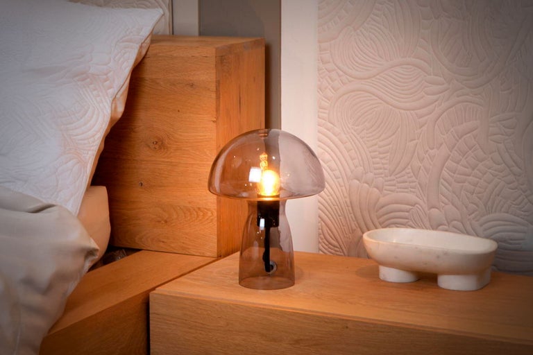 Lampă decorativă de masă din sticlă pe o noptieră din dormitor.