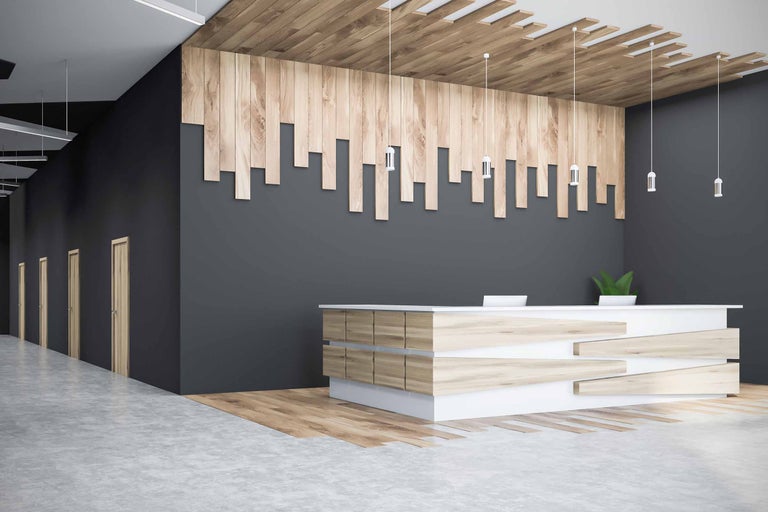 Hol de birou cu lambriuri din lemn, recepție și lămpi suspendate.