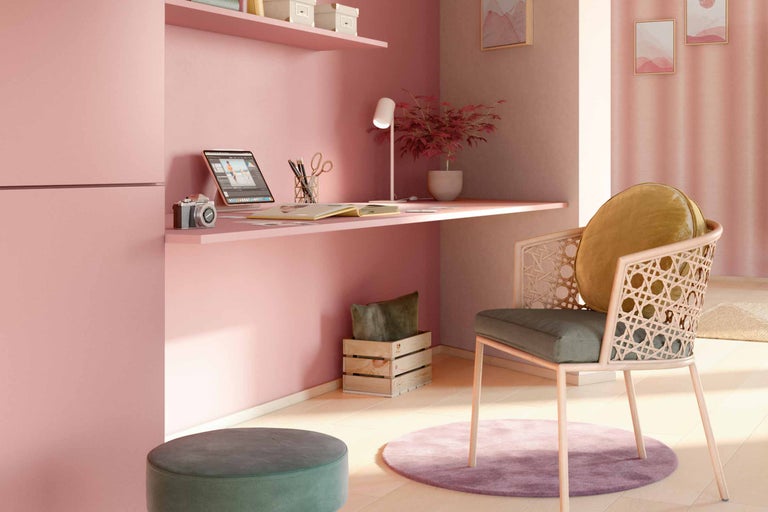 O cameră de lucru cu birou, scaun, lampă și decorațiuni.