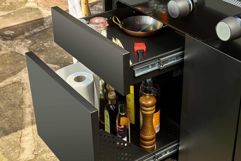 Sertare deschise ale unui dulap de grătar cu ustensile de gătit și ingrediente