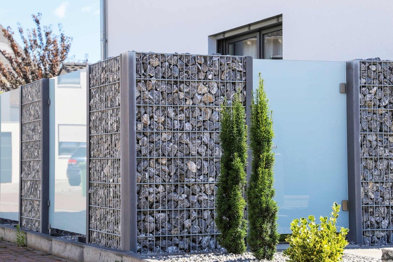 Gard gabion cu umplutură de piatră și elemente de sticlă ca paravan de confidențialitate