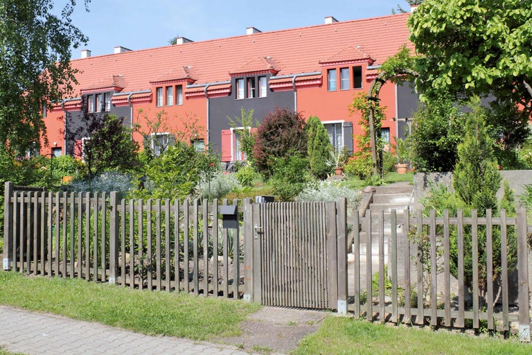 Case înșiruite cu gard din lemn și grădini