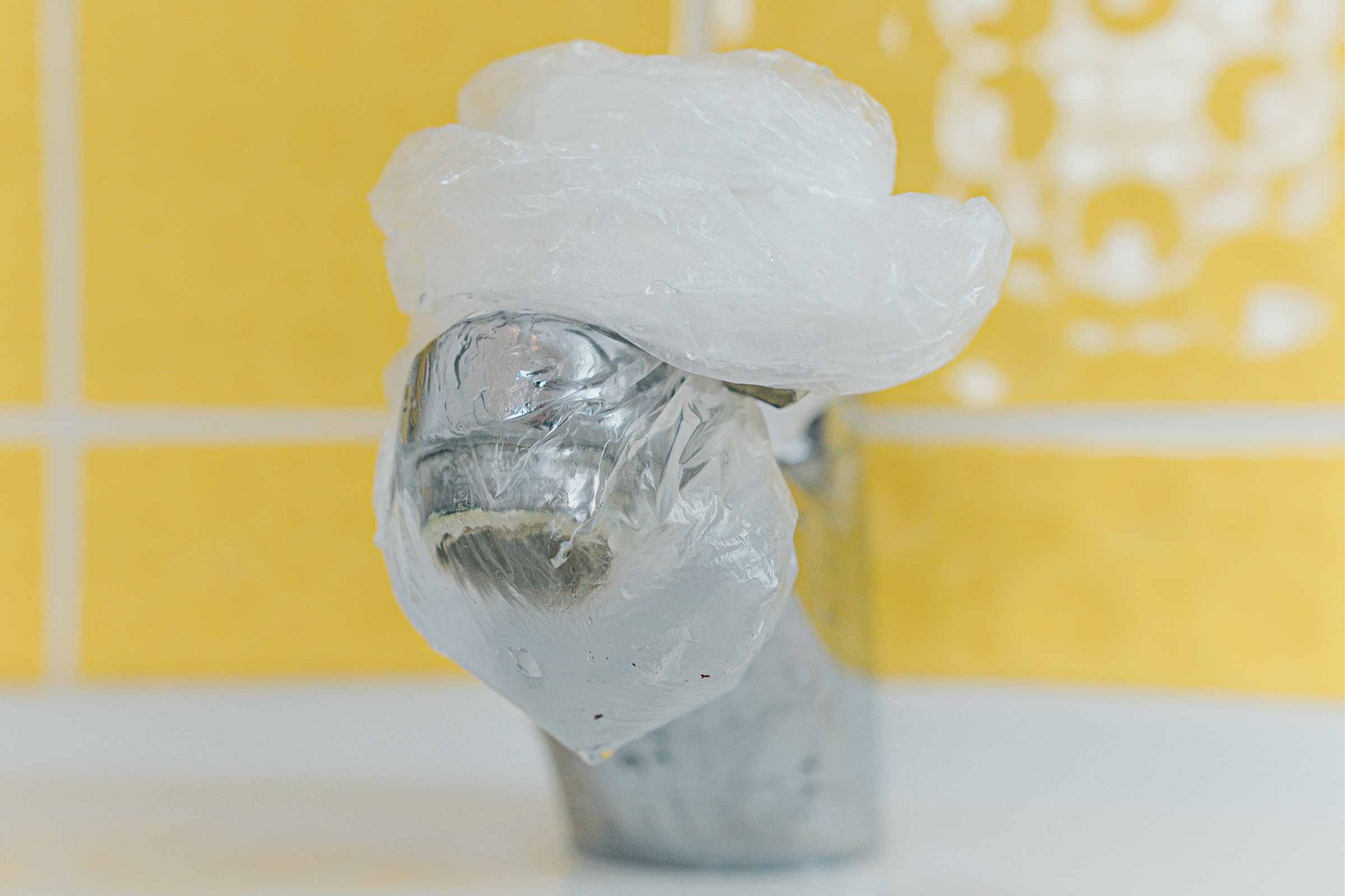 Un robinet este acoperit cu o pungă de plastic.