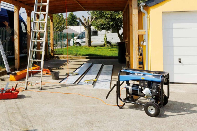 Scenă cu generator, scară, unelte și materiale de construcție în exterior