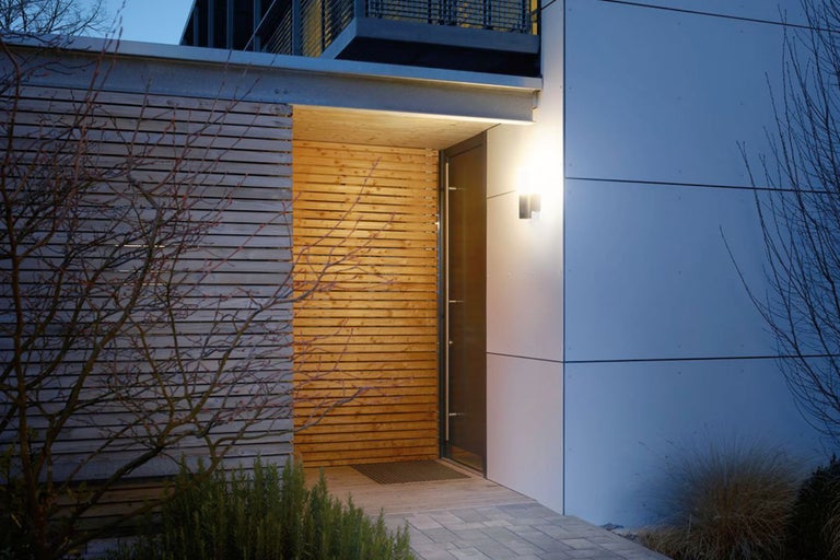 Fațadă modernă de casă cu placare din lemn și iluminat exterior