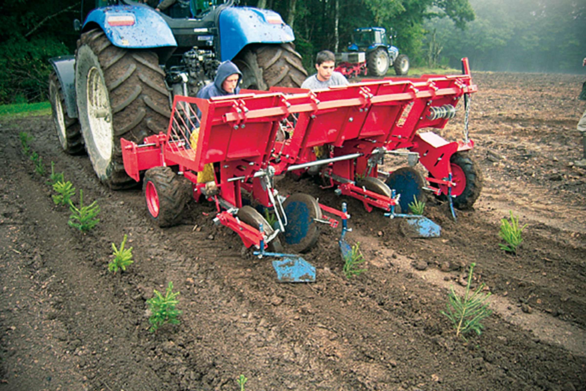 Scenă cu un tractor cu o mașină de plantat care transplantează copaci pe un câmp.