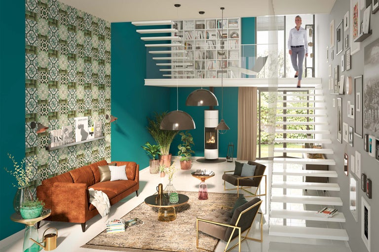 Cameră de zi luminoasă cu canapea, șemineu, scară, decorațiuni și bibliotecă pentru un ambient de locuit modern.