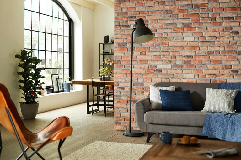 Cameră de zi cu perete de cărămidă, lampadar și fotoliu din piele