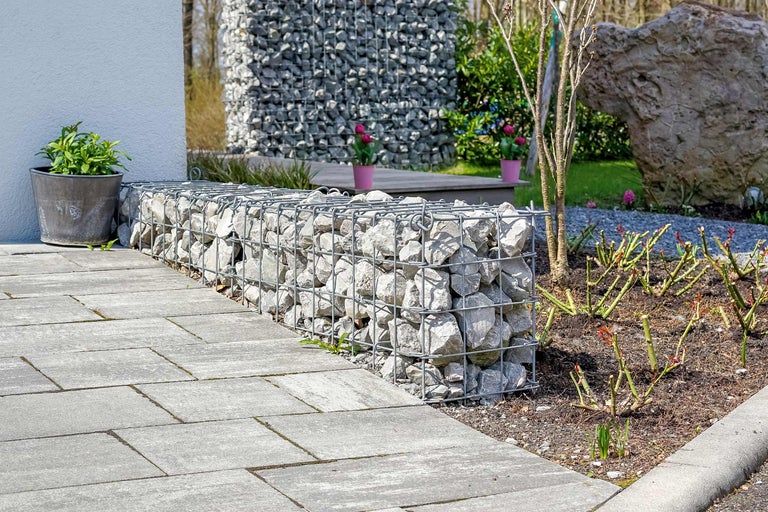 Exterior cu bancă de gabion, pavaj de piatră și plantă într-un ghiveci