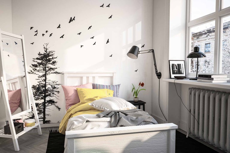 Dormitor cu pat, noptieră, lampă și decorațiuni de perete cu motive de păsări și copaci