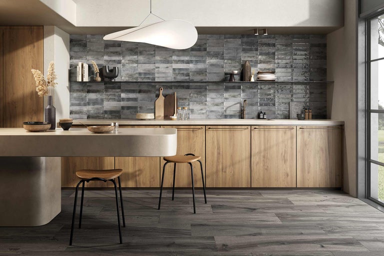 Bucătărie luminoasă cu elemente din lemn, faianță gri și scaune moderne