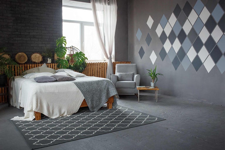 Dormitor luminos cu pat dublu, fotoliu, măsuță și covor