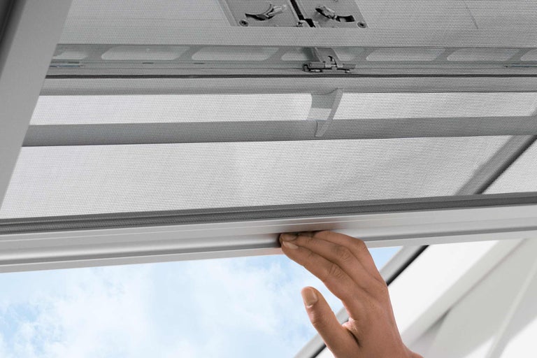 Mână operând plasă de insecte pentru fereastră