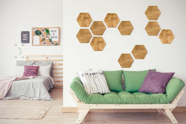 Cameră luminoasă cu pat, futon și plăci de perete hexagonale din lemn