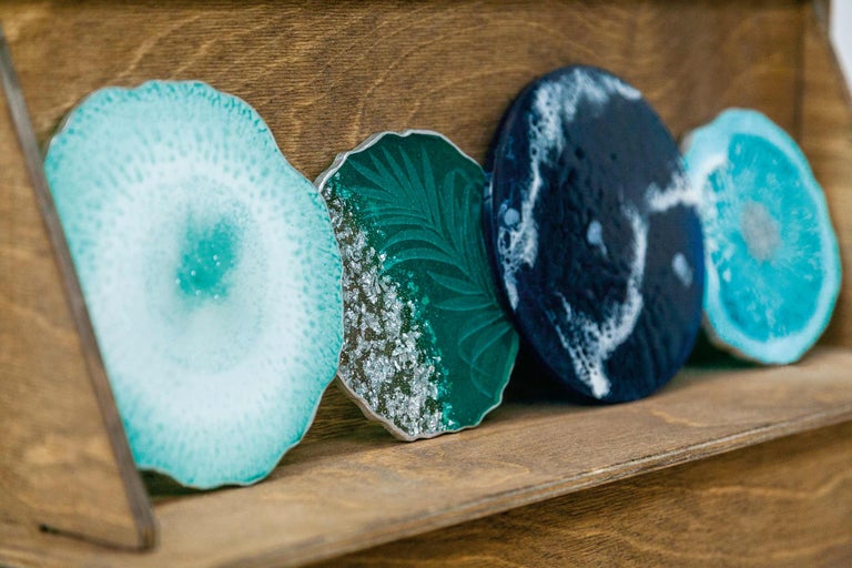 Suporturi decorative din rășină sintetică pe un raft din lemn.