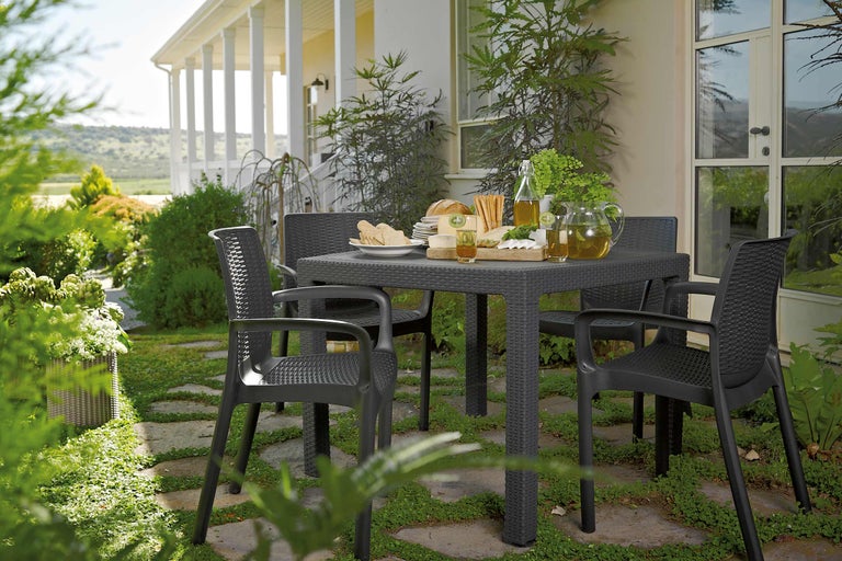 Scenă de grădină cu masă și patru scaune pe o terasă