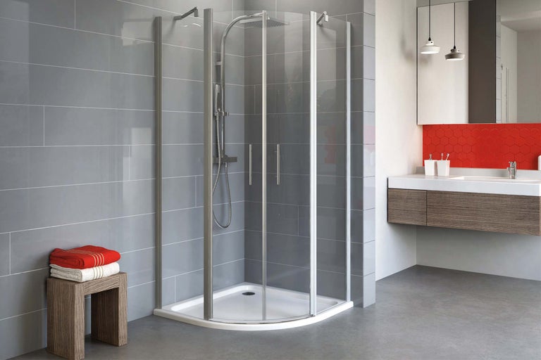 Cabină de duș pe colț cu cadă de duș în baie modernă cu dulap sub chiuvetă și prosoape