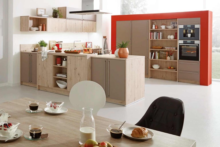 Bucătărie luminoasă și modernă cu insulă de gătit, dulapuri încorporate, rafturi și masă de sufragerie.