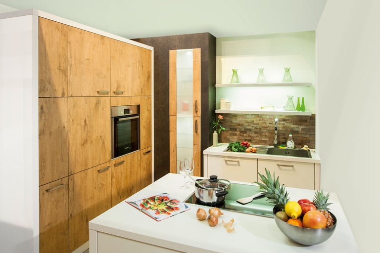 Bucătărie luminoasă cu dulapuri din lemn, plită și chiuvetă