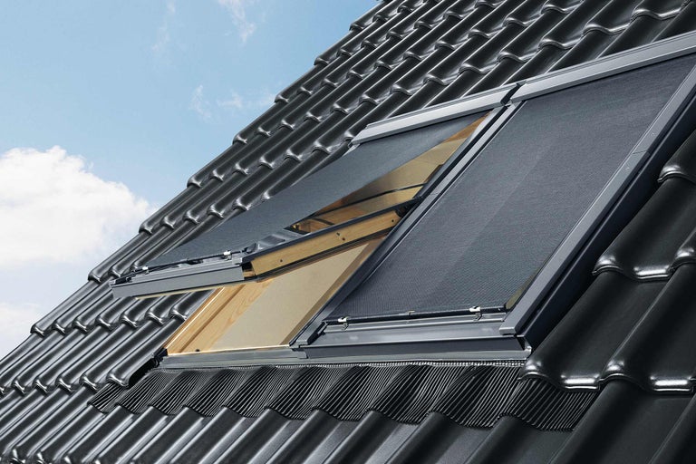 Ferestre de mansardă cu jaluzele de protecție solară pe un acoperiș