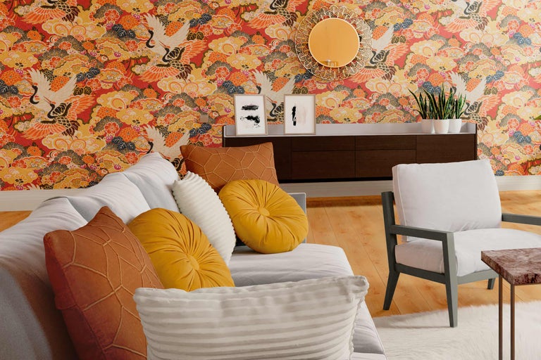 Cameră de zi cu canapea, fotoliu, comodă, oglindă, tablouri și tapet cu motiv de cocori.