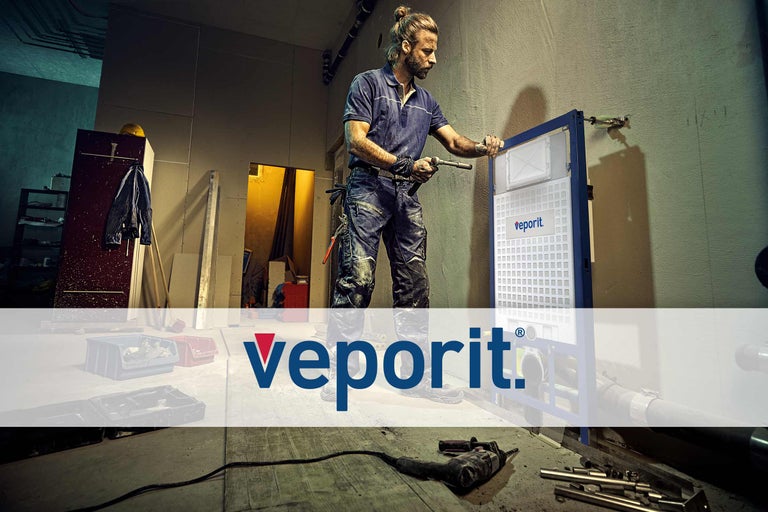 Un instalator instalează un sistem de rezervor de apă Veporit cu unelte într-o baie.