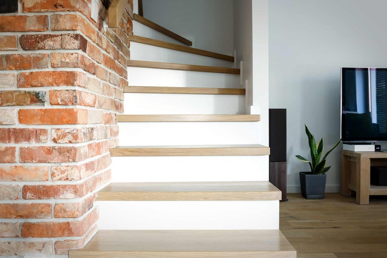 Scară cu trepte din lemn și perete din cărămidă