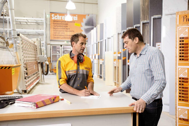Un angajat Hornbach consiliază un client la un tejghea