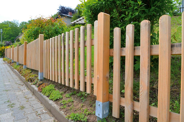 Gard de lemn de-a lungul unei căi în grădină.