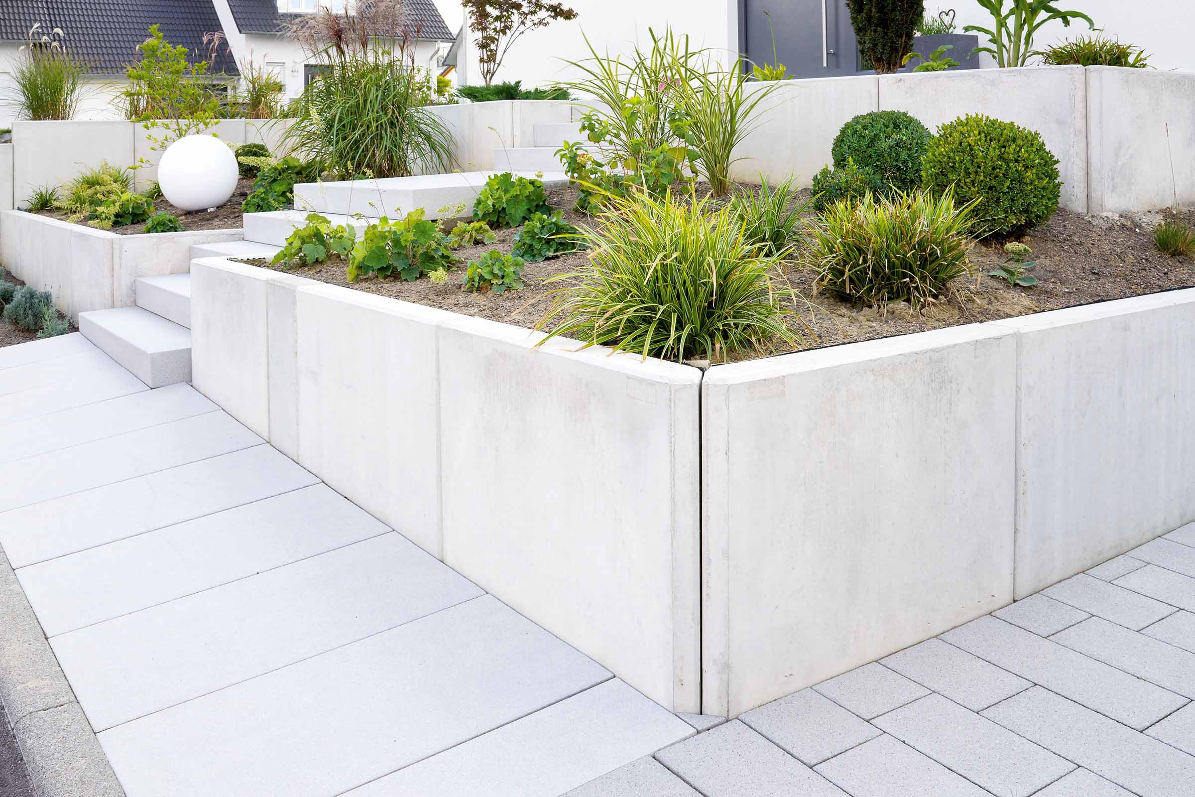 Grădină amenajată cu zid de beton și vegetație