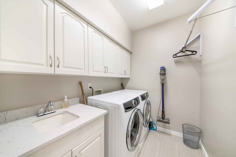 Spălătorie cu mașină de spălat, uscător, chiuvetă, dulapuri și aspirator