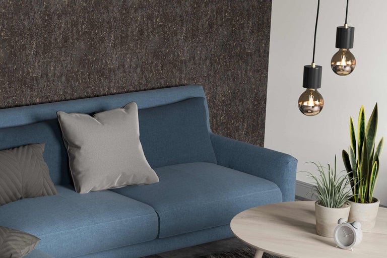 Living cu canapea albastră, perne, măsuță de cafea, plante de interior și lămpi suspendate