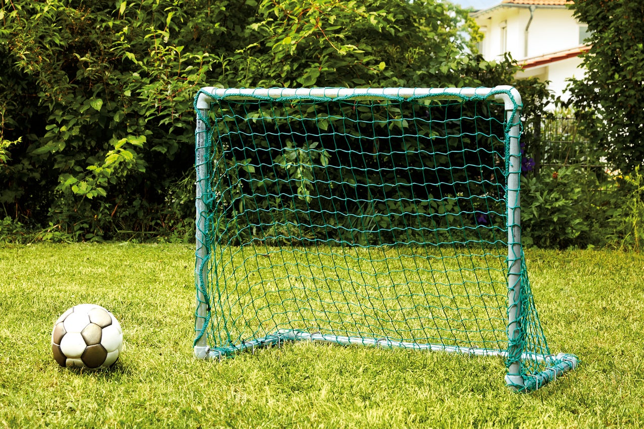 Poartă de fotbal cu minge de fotbal pe gazon