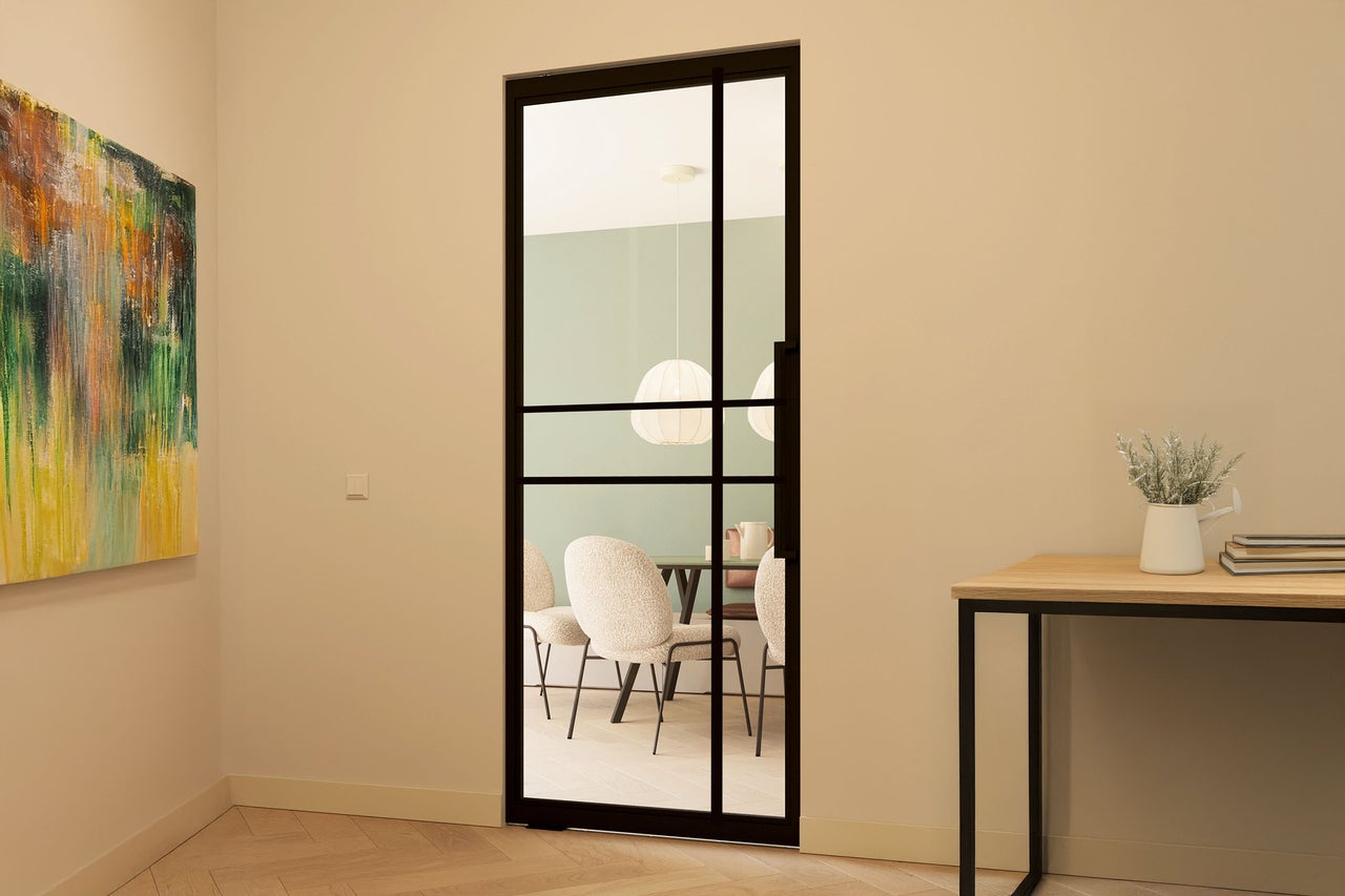 Ușă de interior cu cadru de oțel și inserție de sticlă într-o cameră luminoasă cu masă de sufragerie