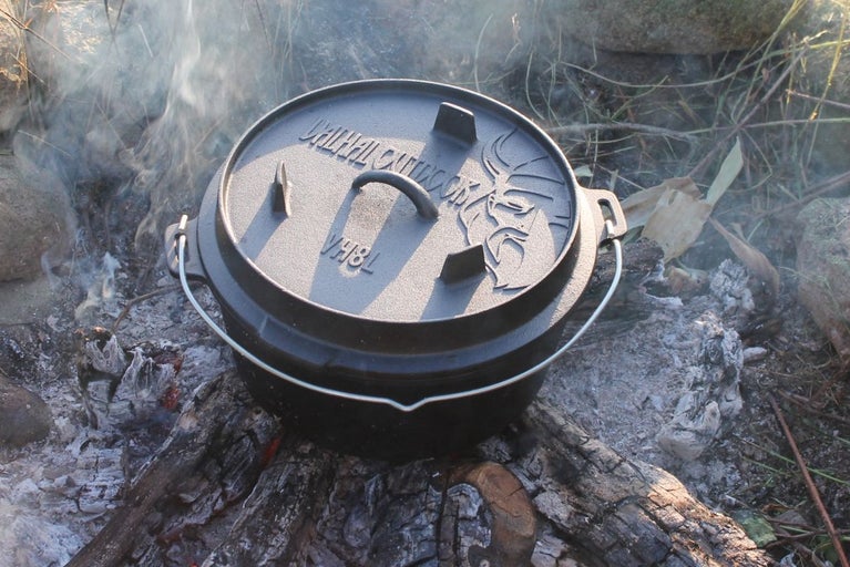 Oală din fontă cu capac pe vatră