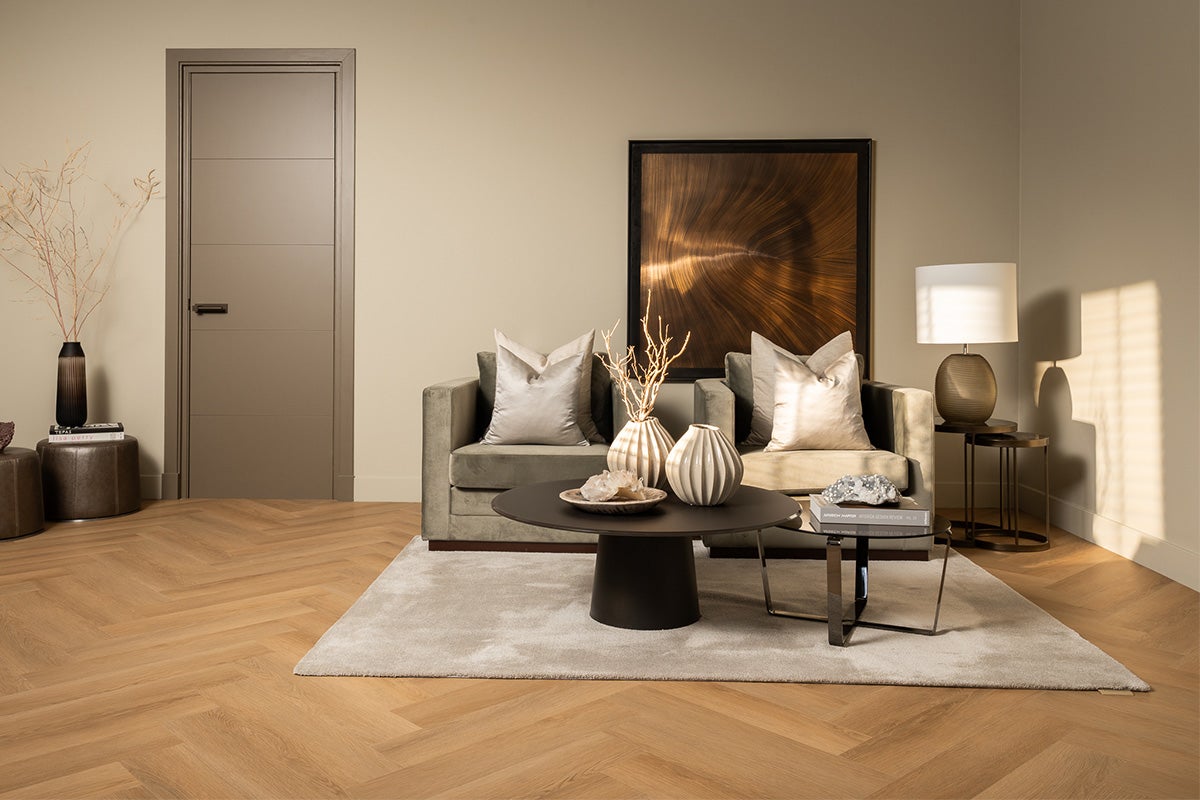 Cameră de zi cu ușă, canapea, masă și decorațiuni pe podea de lemn