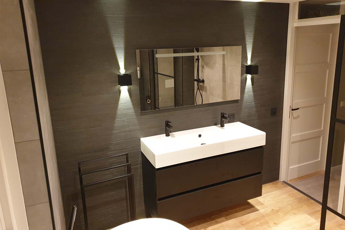 Baie modernă cu lavoar, oglindă și lămpi de perete