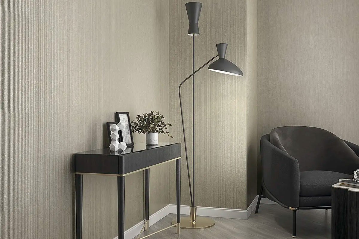 Living cu lampă de podea, consolă, decorațiuni și fotoliu în fața tapetului de perete