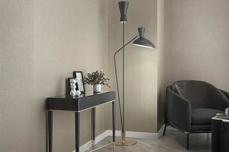 Living cu lampă de podea, consolă, decorațiuni și fotoliu în fața tapetului de perete