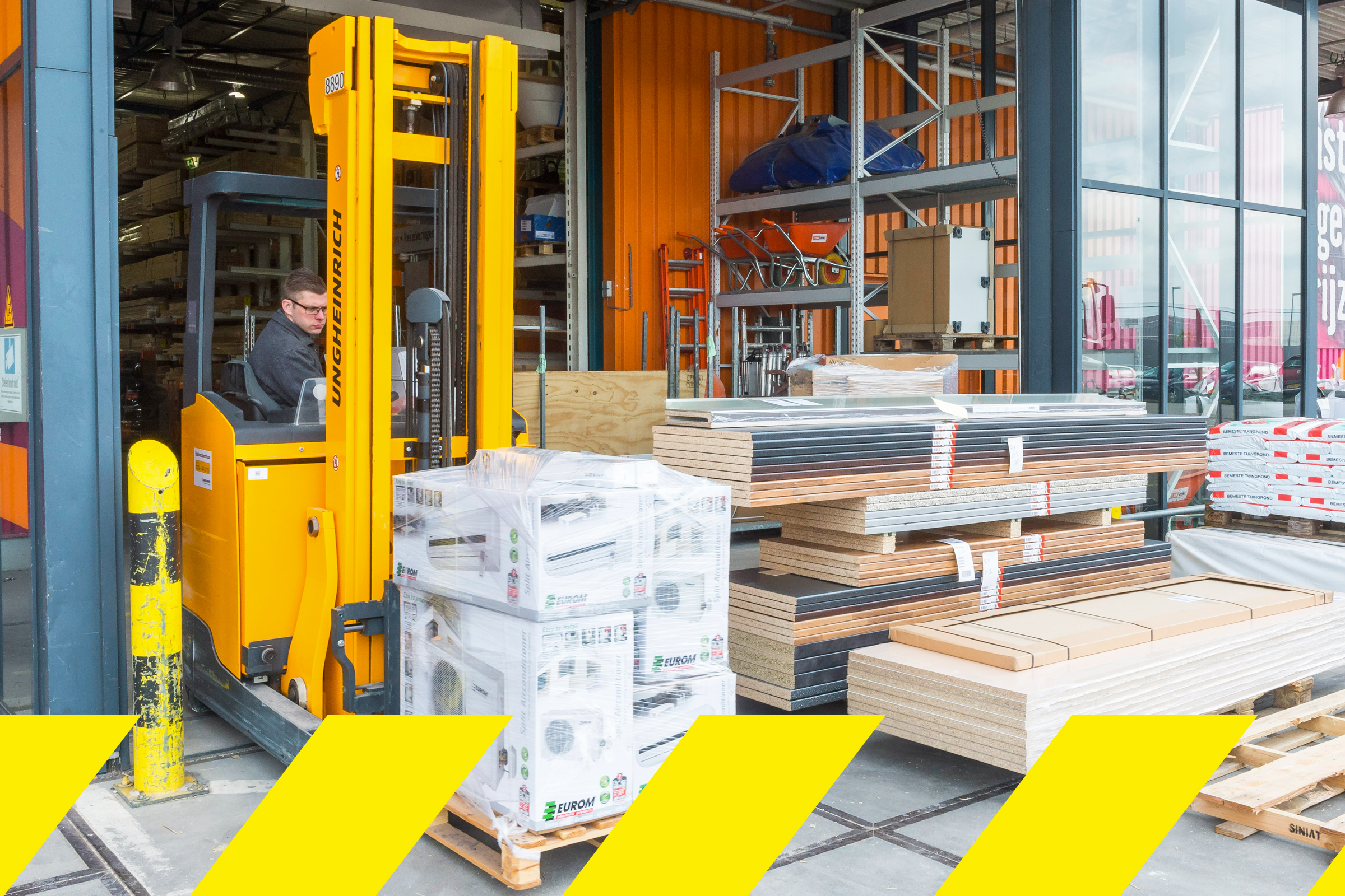 Un stivuitor cu un operator în zona de depozit Hornbach transportă mărfuri.