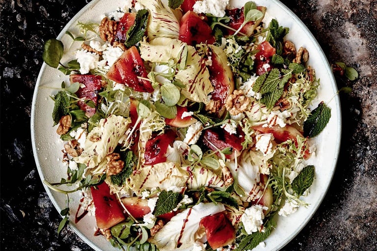 Farfurie cu salată cu pepene verde, brânză, frunze de salată, mentă și nuci