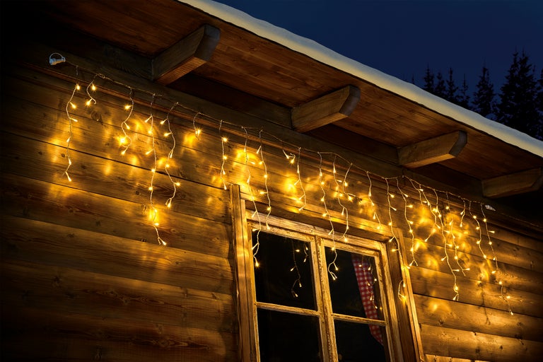 Fațadă de casă din lemn cu fereastră și ghirlandă luminoasă pentru decorare